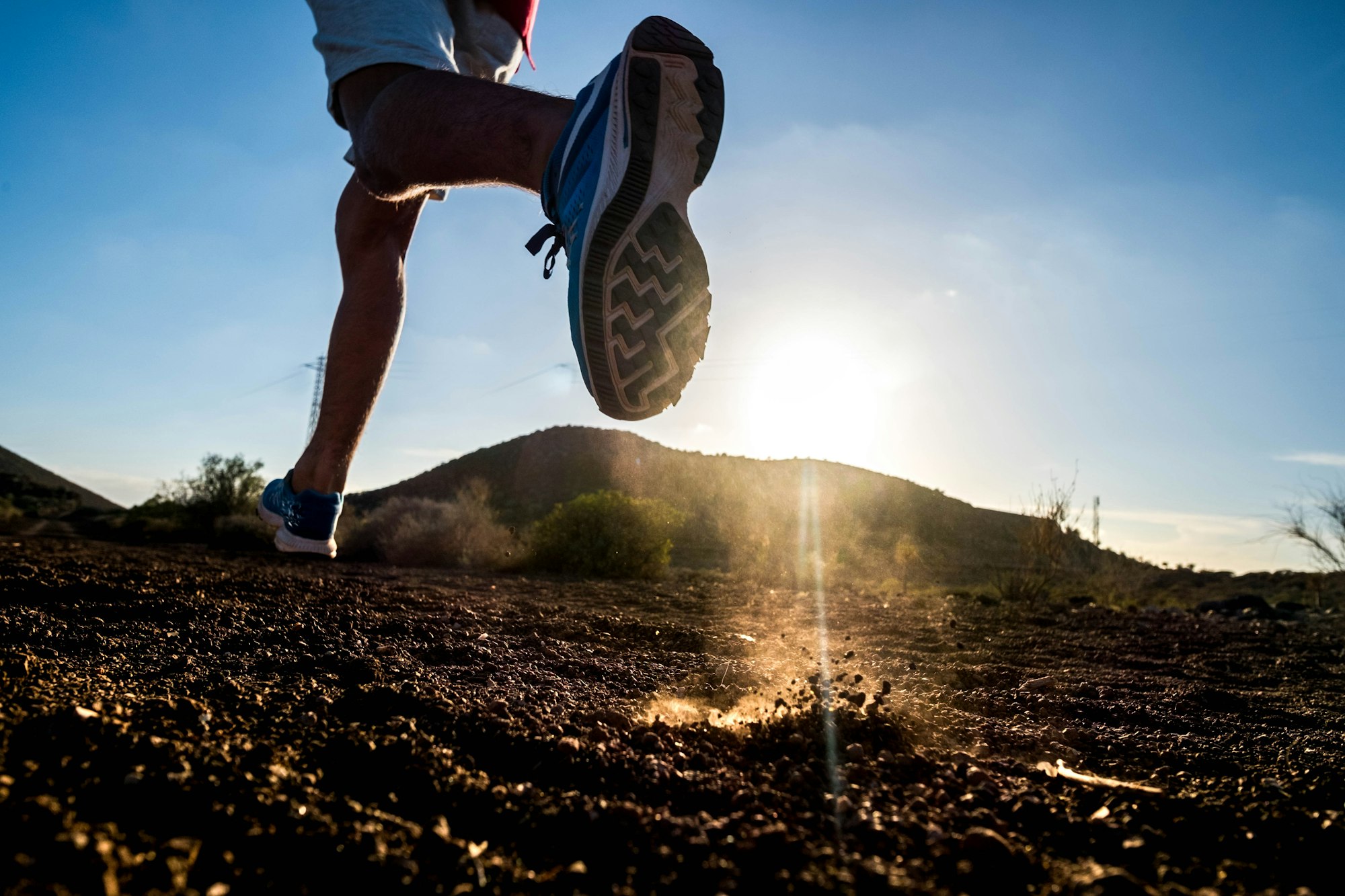 close up of foot of man running alone in the mountains - active and fitness people lifestyle